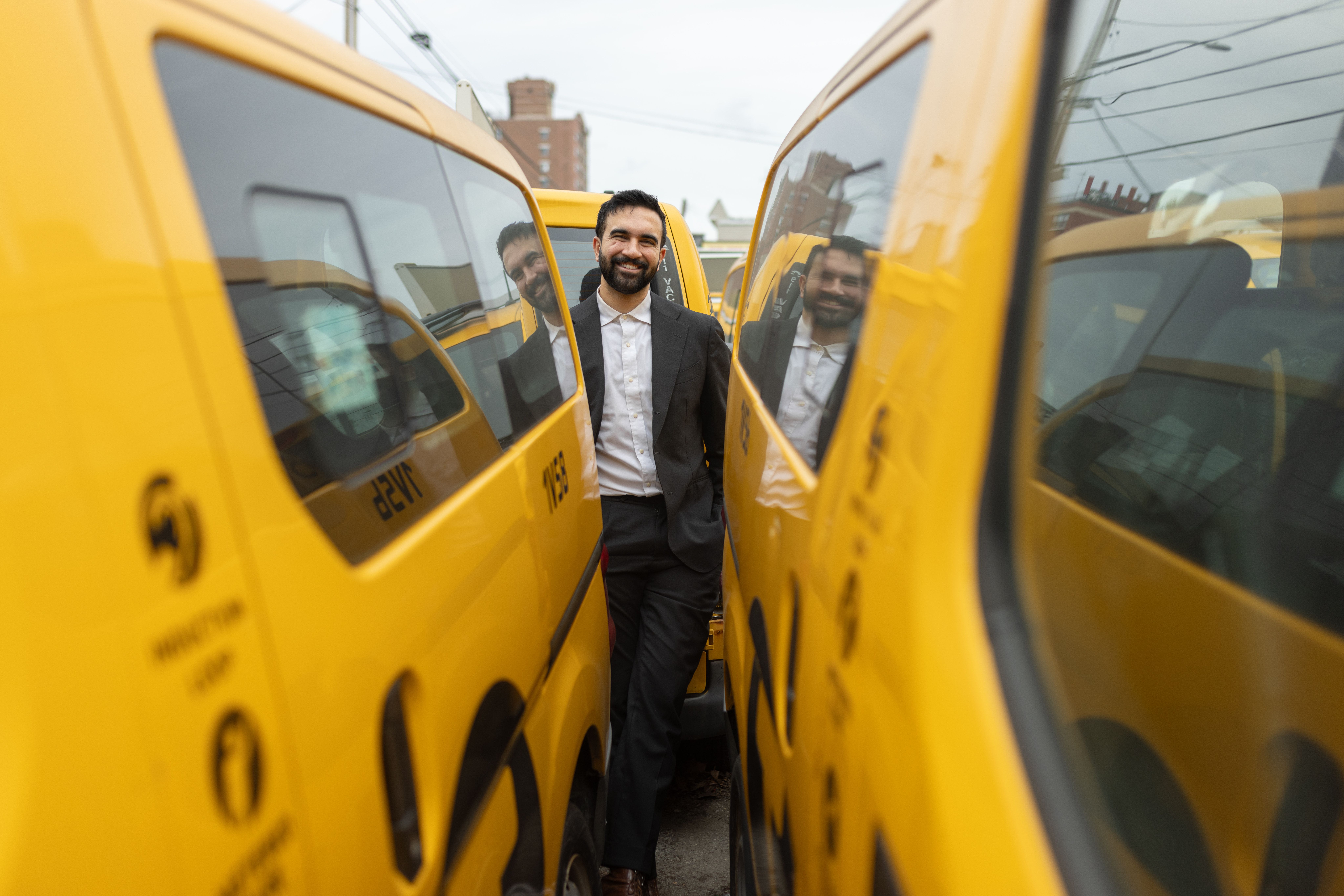 Wie Zohran Mamdani Politik neu brandet und was Kommunikationsprofis daraus lernen können Zohran Mamdani steht im Anzug zwischen gelben New Yorker Taxis und lächelt in die Kamera.